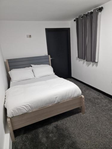 CodsallCKB Flat- comfort, cosy, and secure!的一间卧室配有一张带白色床单的大床