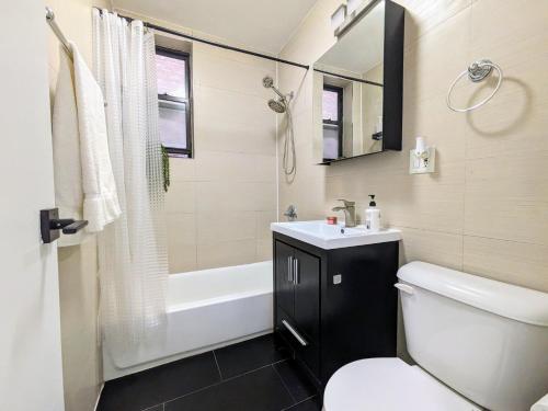 纽约Lavish Downtown Manhattan Oasis in Union Square的浴室配有卫生间、盥洗盆和浴缸。
