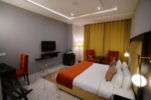 拉合尔Faletti’s Grand MM Alam Road的一间卧室配有一张床、一张书桌和一台电视