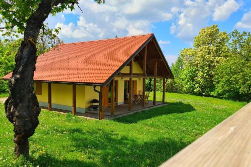 Dol pri HrastnikuForester's Hut With Whirlpool & Sauna - Happy Rentals的绿色田野中带红色屋顶的黄色小屋