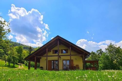 Dol pri HrastnikuForester's Hut With Whirlpool & Sauna - Happy Rentals的一座小房子,位于一座小山上,有一片绿地