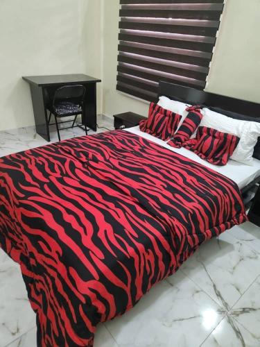 阿布贾LA VIVA AIRBNB的一张带红黑斑马毯子的床