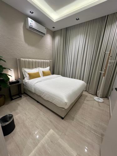 利雅德Three Bedroom furnished apartment in north Riyadh的一间卧室配有带白色床单和黄色枕头的床。