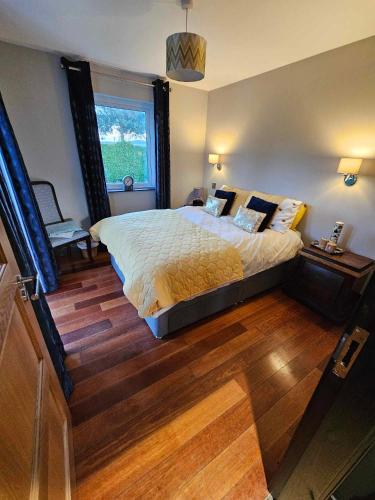 埃格林顿Harmony Cottage的一间卧室设有一张大床和一个窗户。