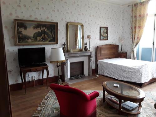 维莱讷-拉瑞埃勒Le Chateau du grand Coudray的客厅配有床和椅子