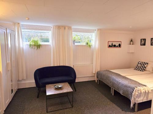 哥本哈根Guesthouse 'Blue House' in vintage villa&garden的一间卧室配有一张床、一把椅子和窗户。