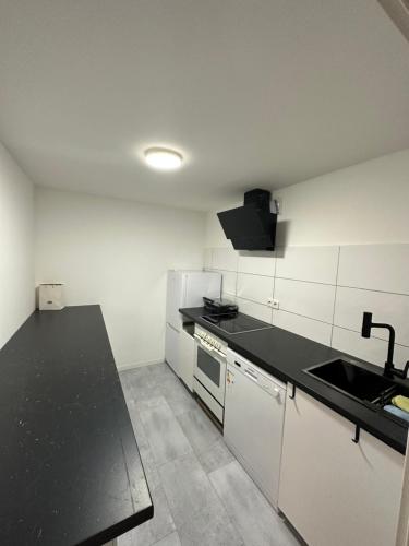 汉诺威Charmante 2 Zimmer Souterrain的厨房配有黑色台面和水槽