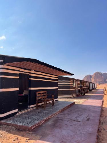 瓦迪拉姆Wadi Rum Magic Camp的旁边设有长凳的小屋