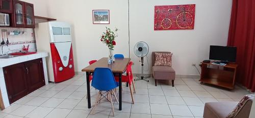 马萨亚Apartamentos Nokal的厨房配有带蓝色椅子的桌子和冰箱。