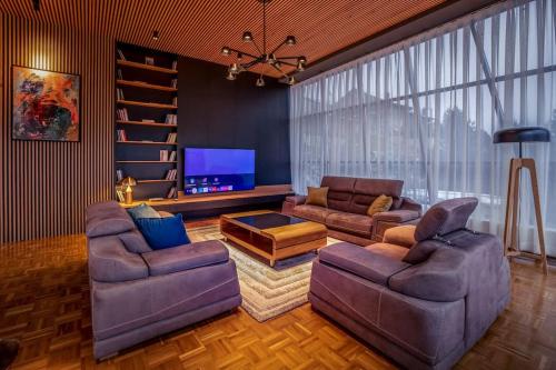 普雷瓦莱Luxurious Villa in Prevalla的客厅配有2张沙发和1台平面电视