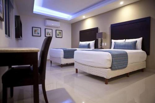 卡波圣卢卡斯Cabo room的酒店客房,配有两张床和椅子