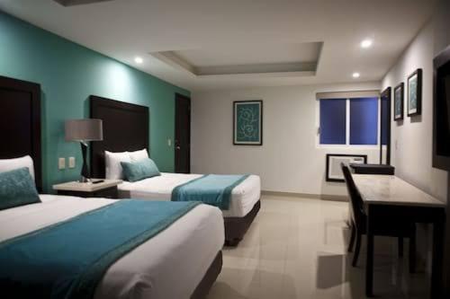 卡波圣卢卡斯Cabo room的酒店客房配有两张床和一张书桌
