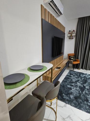 阿克拉Modern & Spacious Studio in Cantonment, Accra的客厅配有桌椅和电视。