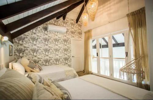 蓬塔卡纳Cap Cana Royal Greem Villege的一间卧室设有两张床和大窗户