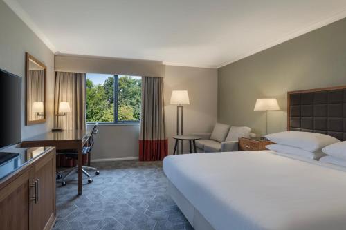 彼得伯勒Delta Hotels by Marriott Peterborough的酒店客房设有一张大床和一张书桌。