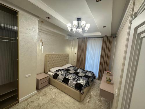 塔什干Luxury studios的一间卧室配有一张床和一个吊灯