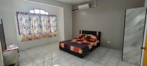 伯豪Homestay Atikah Bahau的一间卧室设有一张床和一个窗口
