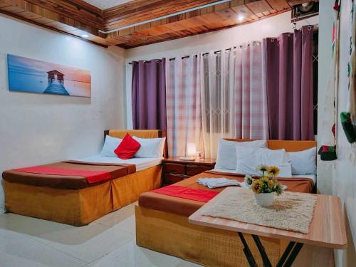 碧瑶Bag-C Vacation House Bed and Breakfast的小房间设有两张床和一张桌子