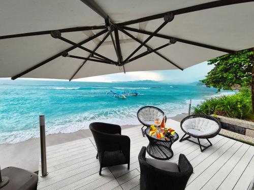 甘地达萨吉塔塞加拉别墅的海滩上带椅子和遮阳伞的甲板