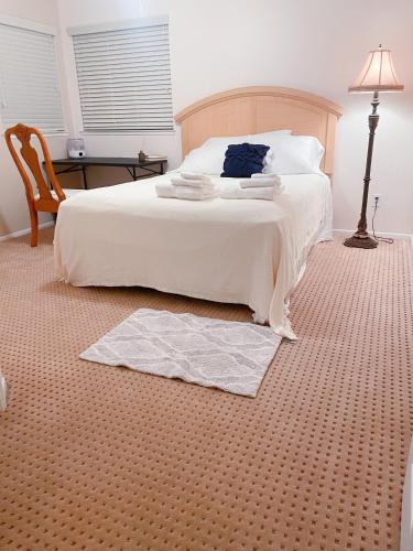 里弗赛德R2-Nice Private Room 2 Riverside的卧室配有白色的床、桌子和灯