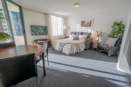布里斯班CBD Central - 1BDR Apt - Sleeps 6 - Sebel 4 Star Resort的卧室配有1张床、1张桌子和1把椅子