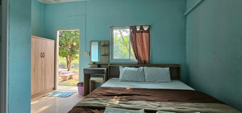 坤西育府Armthong Resort的蓝色的客房设有床和窗户。