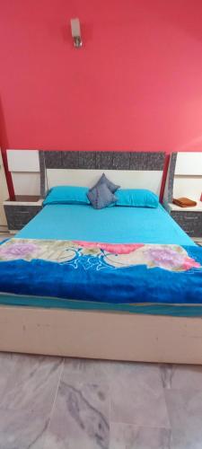 卡拉奇Maymar Holiday Home的粉红色墙壁的房间里一张床位