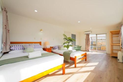 旺阿雷5-Bedroom Fully-Equipped Home in Whangarei的一间卧室设有两张床和大窗户