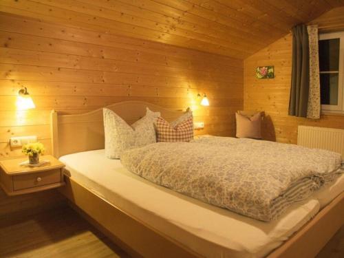 巴尔德赫旺2 in Alpenrösle Modern retreat的卧室配有木墙内的一张床