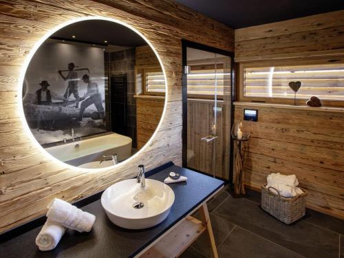 奥伯斯特多夫Alpglück Chalet Modern retreat的浴室配有盥洗盆、镜子和浴缸