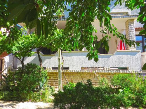 梅杜林Ferienwohnung für 2 Personen ca 28 qm in Medulin, Istrien Südküste von Istrien的前面有棵树的建筑