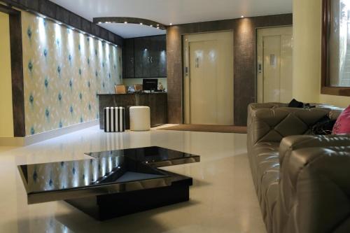 古瓦哈提Mayur Residency Hotel的客厅配有沙发和桌子