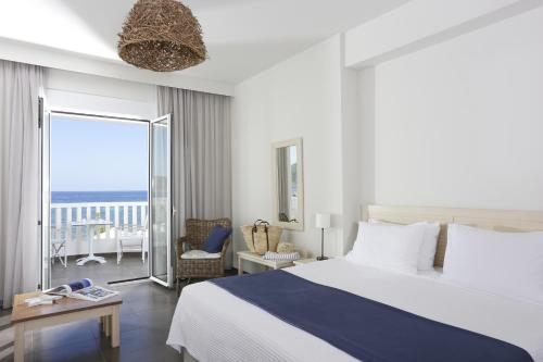马拉松波利斯阿尔蒂娜诺沃酒店的一间卧室配有一张床,享有海景