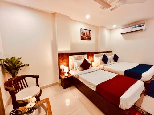 瑞诗凯诗Sandhya INN的酒店客房,配有两张床和椅子
