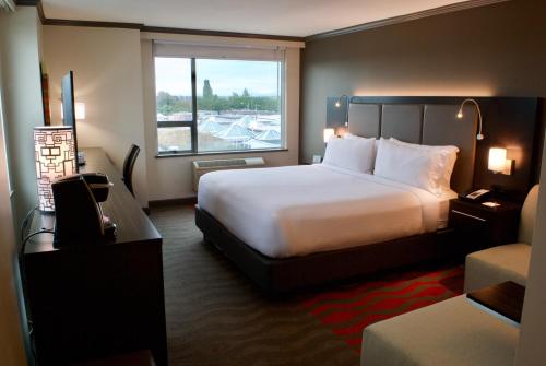 里士满里士满温哥华机场假日酒店的一间设有大床和窗户的酒店客房