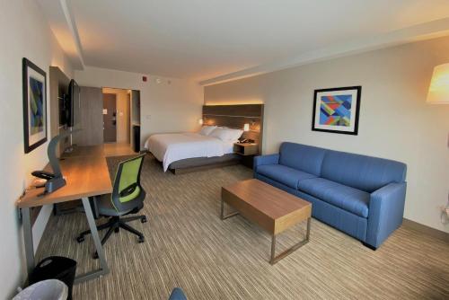 奥罗拉Holiday Inn Express & Suites - Aurora, an IHG Hotel的酒店客房,配有床和蓝色的沙发