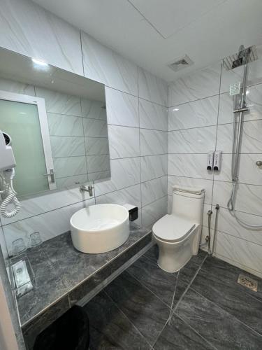 麻坡52典雅宾馆的一间带水槽、卫生间和镜子的浴室