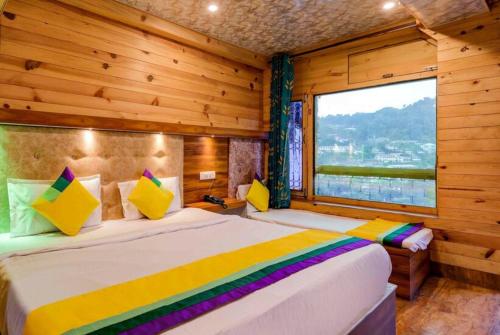 奈尼塔尔Goroomgo Vinayak Mall Road Lake View Nainital - Luxury Room - Best Hotel in Nainital的一间卧室设有两张床和大窗户