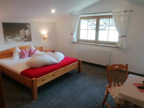 索尔登阿尔卑雅格乡间别墅酒店的一间卧室设有一张床、一个窗口和一把椅子