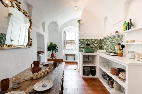 奥斯图尼Le Piccole Case Bianche的厨房配有木桌和镜子