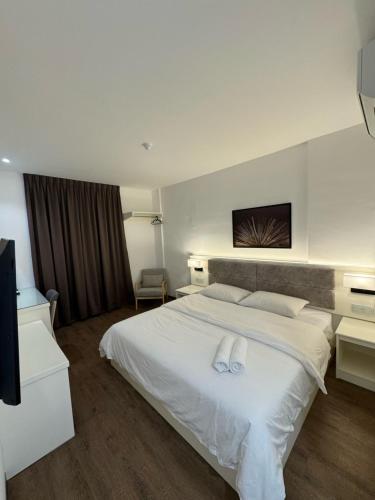 麻坡52典雅宾馆的卧室配有白色的床和2条毛巾