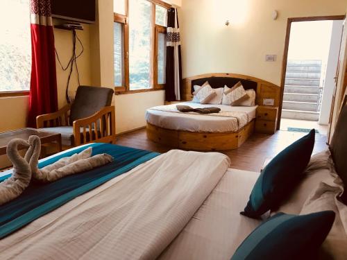 钱德加尔DevDham Lodge的酒店客房,设有两张床和一张沙发