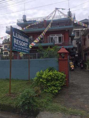 博卡拉Hotel Lumbini Resort的房屋前有标志的建筑物