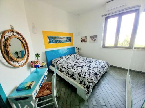 蒙德罗Villa Mondello Terraces & Jacuzzi的一间卧室配有一张床、一张桌子和一面镜子
