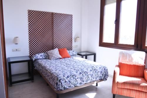 塞维利亚SE - Peaceful Shiny Apartment Near Fibes的卧室配有床、椅子和窗户。