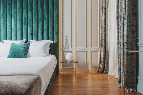 波尔多Hôtel Singulier Bordeaux的一间卧室配有一张带绿色墙壁的床