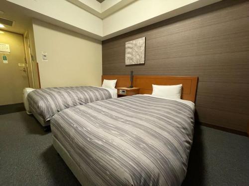 旭川旭川站一条通路特客栈及酒店的一间酒店客房,房间内设有两张床