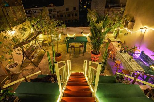 芭堤雅市中心Happiness Community Wake & Bake Hostel - Rooftop Bar & Bistro的享有带桌子和植物的露台的顶部景色
