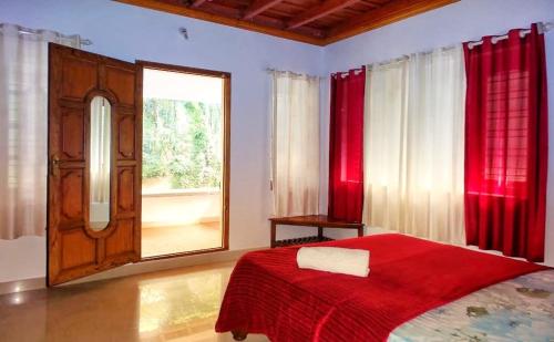 桑提科帕Divine Gift Coorg Homestay的一间卧室设有红色的床和窗户。