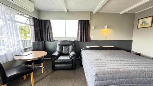 旺阿雷中央法院汽车旅馆的一间卧室配有一张床、一把椅子和一张桌子